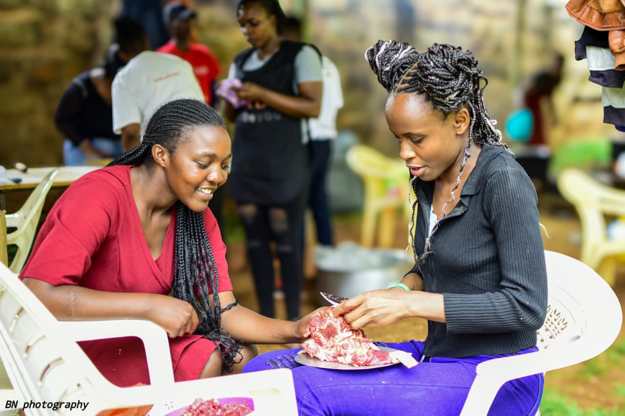 two ladies cutting meat during the chapati festival